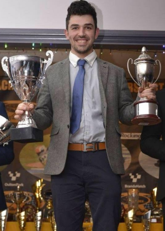 Greg Madero, founder of Auto Elite 60, with motorsport trophies